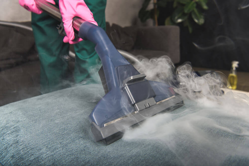 close up of a steam upholstery cleaner vacuum with steam coming out everywhere
